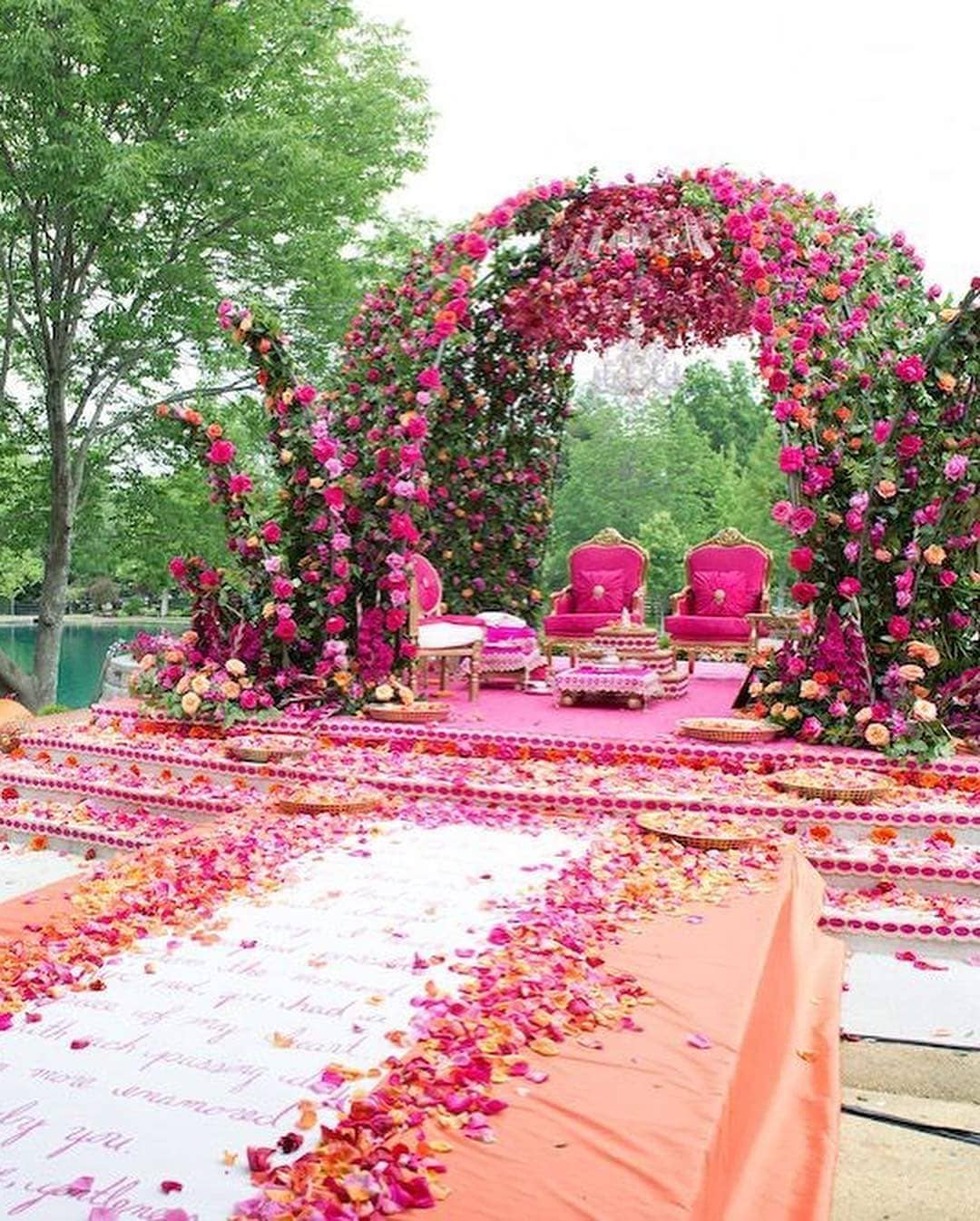 Wedding mandap decoration with pink flowers and wedding vows printed on the Aisle plus with pink and golden colour wedding mandap chairs