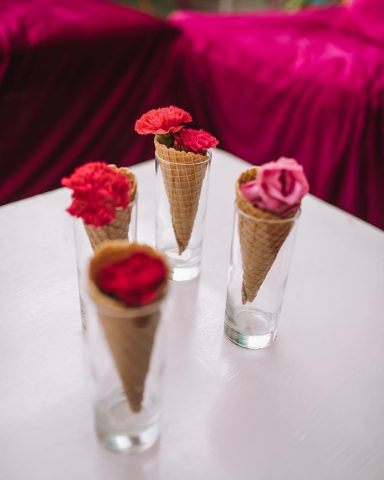 simple and inexpensive wedding centerpiece idea with ice cream cones and a handful of flowers