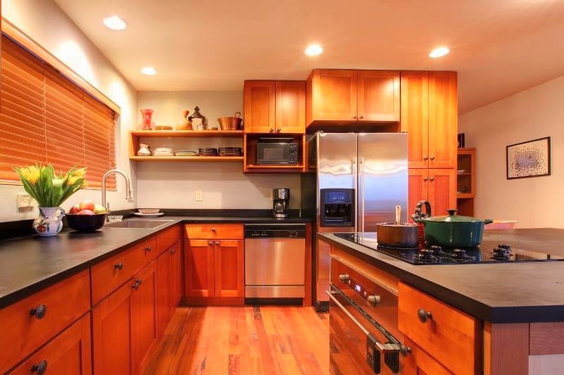 Open kitchen with wooden cabinets and island stove